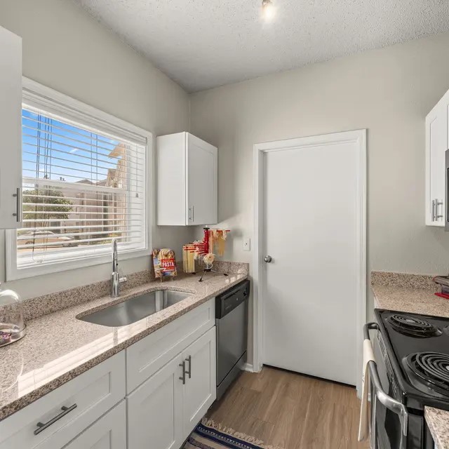 13005 Heinemann Drive, Unit 131312 Austin, TX 78727 - Photo 8 of 17 a kitchen with a sink stove top oven and cabinets
