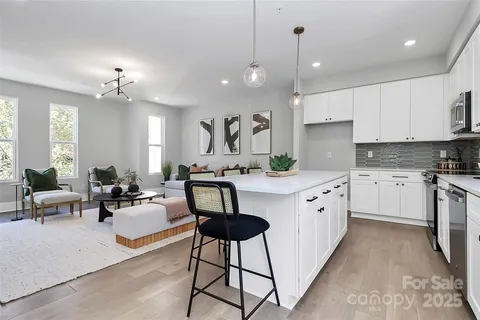 a kitchen with kitchen island granite countertop a white center island a sink stainless steel appliances and cabinets