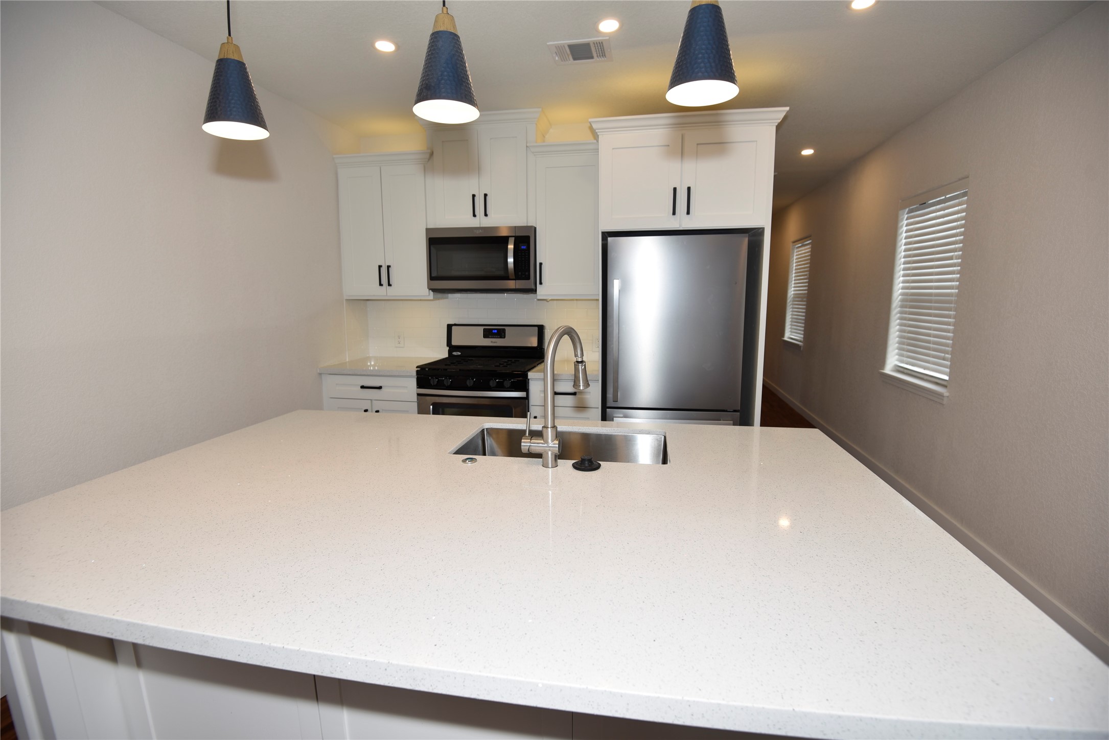4322 Allen Street Houston, TX 77007 - Photo 14 of 17 a kitchen with stainless steel appliances a refrigerator oven a sink a stove a dining table and chairs with wooden floor