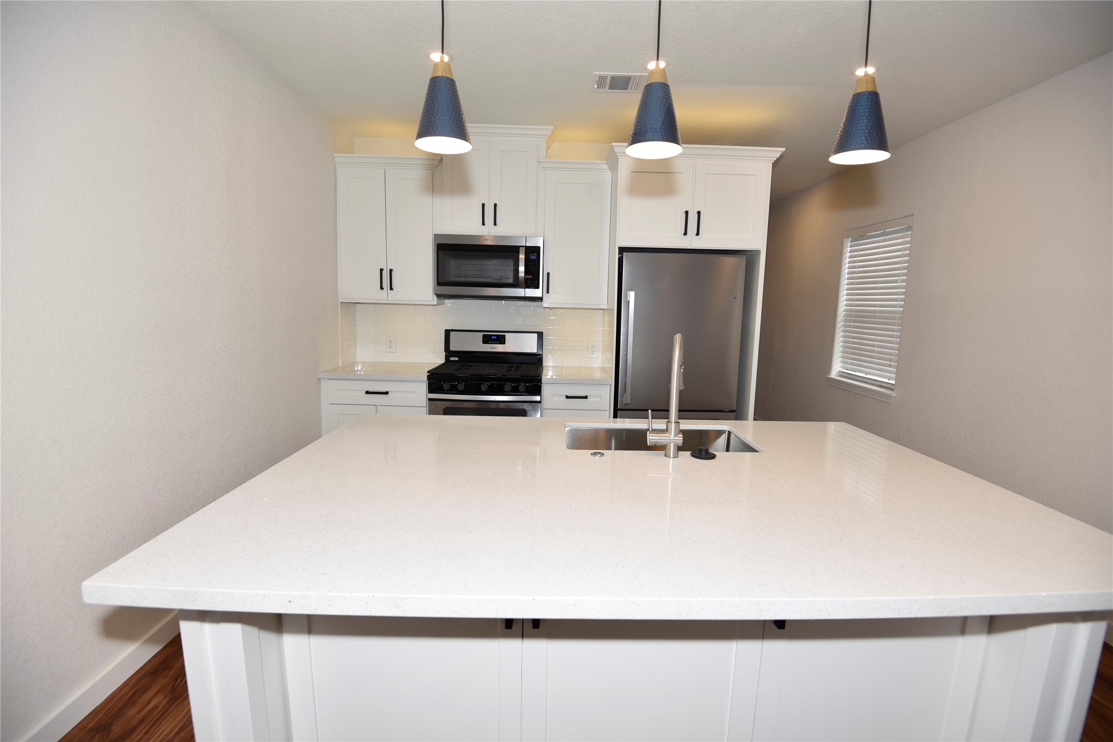 4322 Allen Street Houston, TX 77007 - Photo 15 of 17 a kitchen with stainless steel appliances a stove top oven a refrigerator a sink and white cabinets