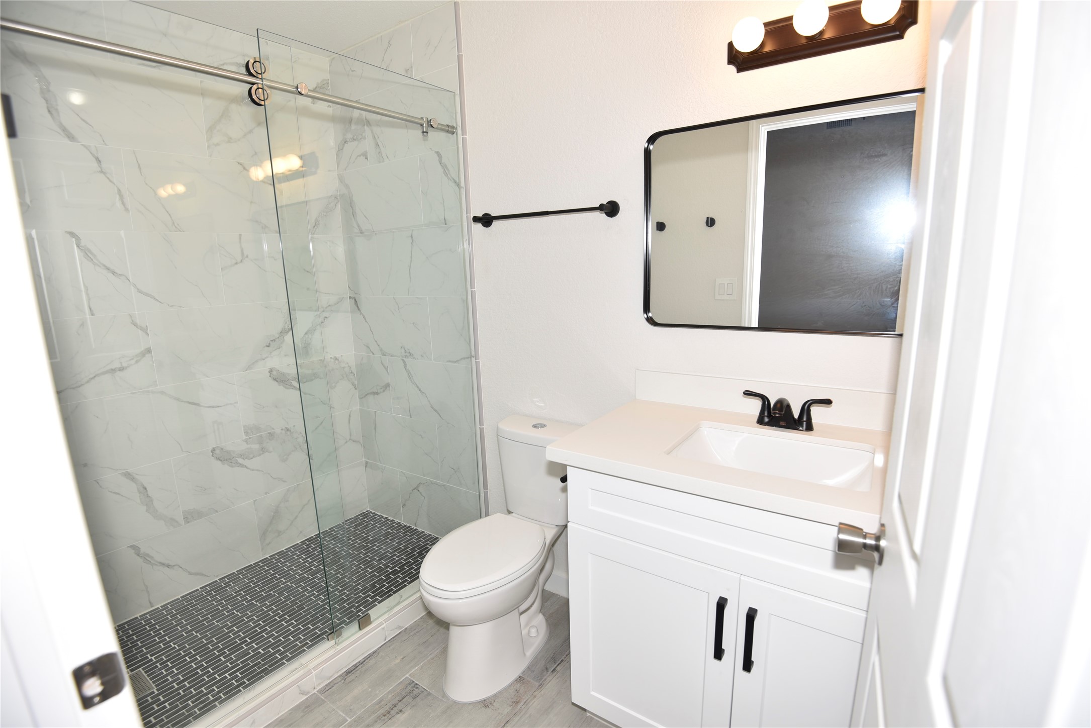 4322 Allen Street Houston, TX 77007 - Photo 7 of 17 a bathroom with a sink toilet a mirror and shower