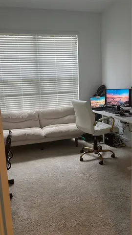 a view of a workspace with furniture and a window