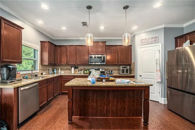 a kitchen with a sink refrigerator and microwave