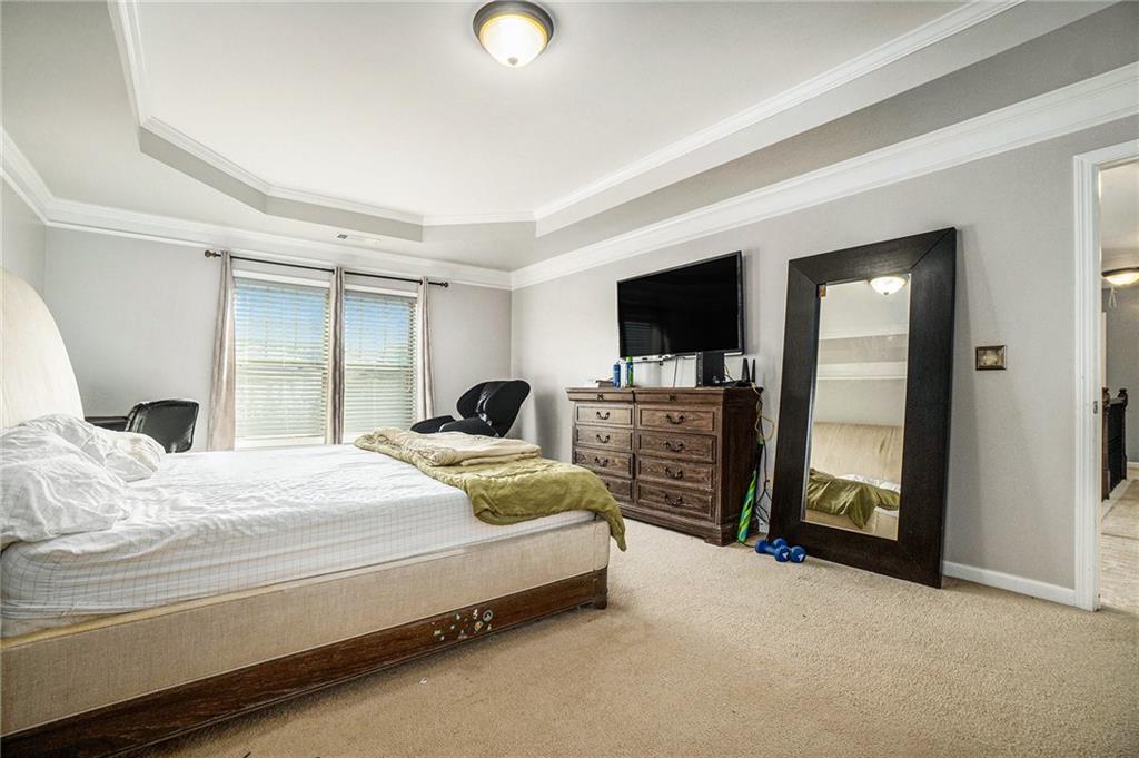 566 Olympic Way Acworth, GA 30102 - Photo 18 of 29 a bedroom with a bed and a flat tv screen on wall