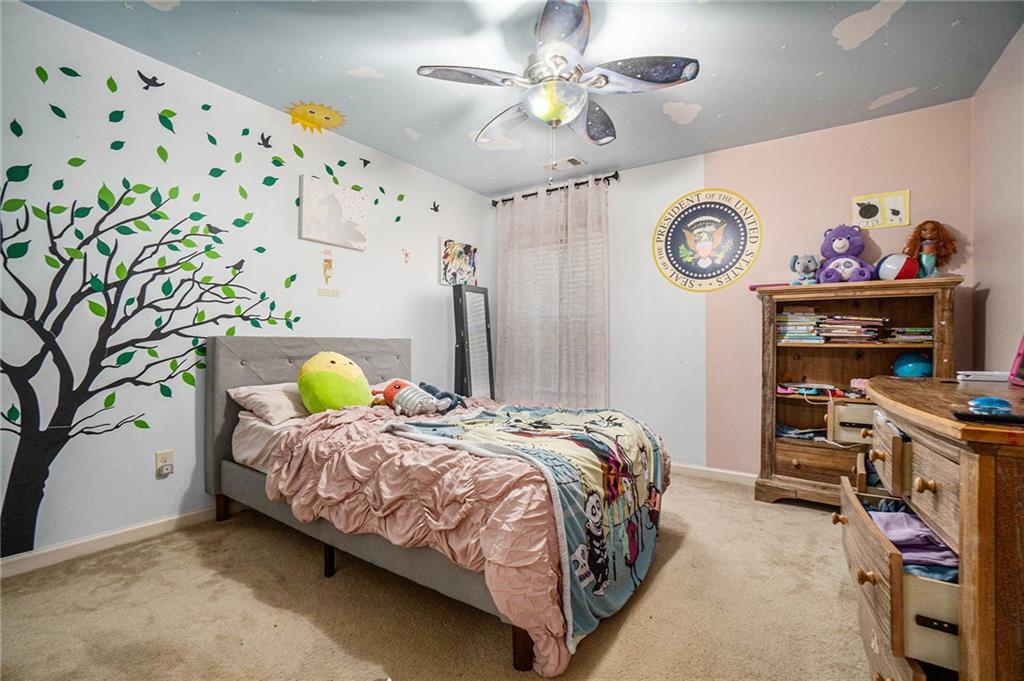 566 Olympic Way Acworth, GA 30102 - Photo 23 of 29 a bedroom with a bed and a chandelier