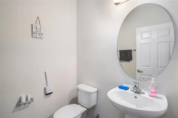 a bathroom with a sink mirror and toilet
