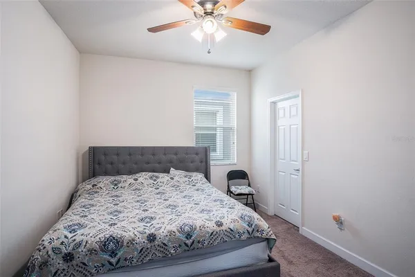 a bed sitting in a bedroom next to a window and a chandelier