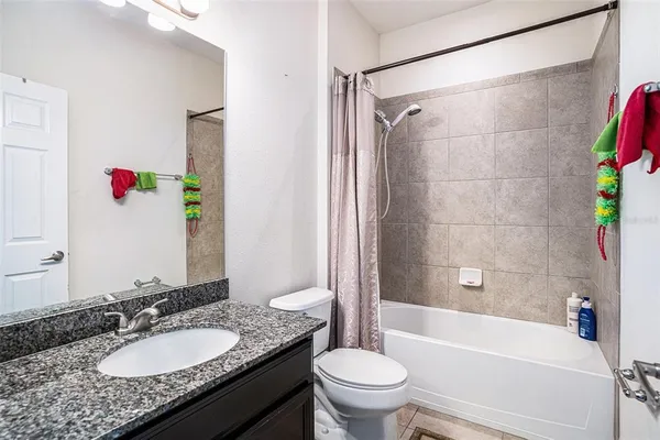 a bathroom with a granite countertop sink mirror toilet and bathtub