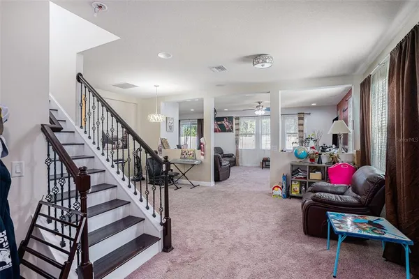 a room with lots of white furniture and stairs