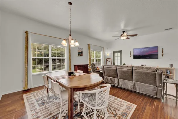 a living room with furniture a flat screen tv and wooden floor