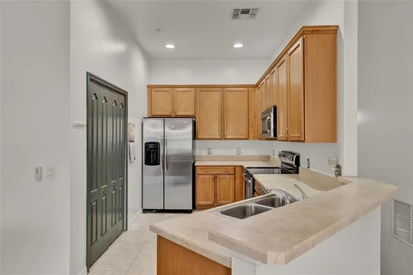 a kitchen with a refrigerator a sink and cabinets