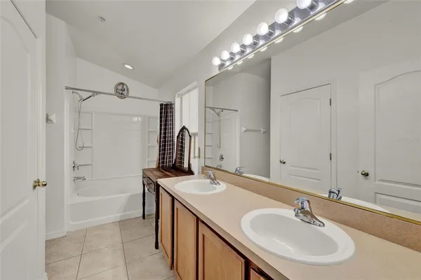 a bathroom with a sink double vanity granite tub and shower