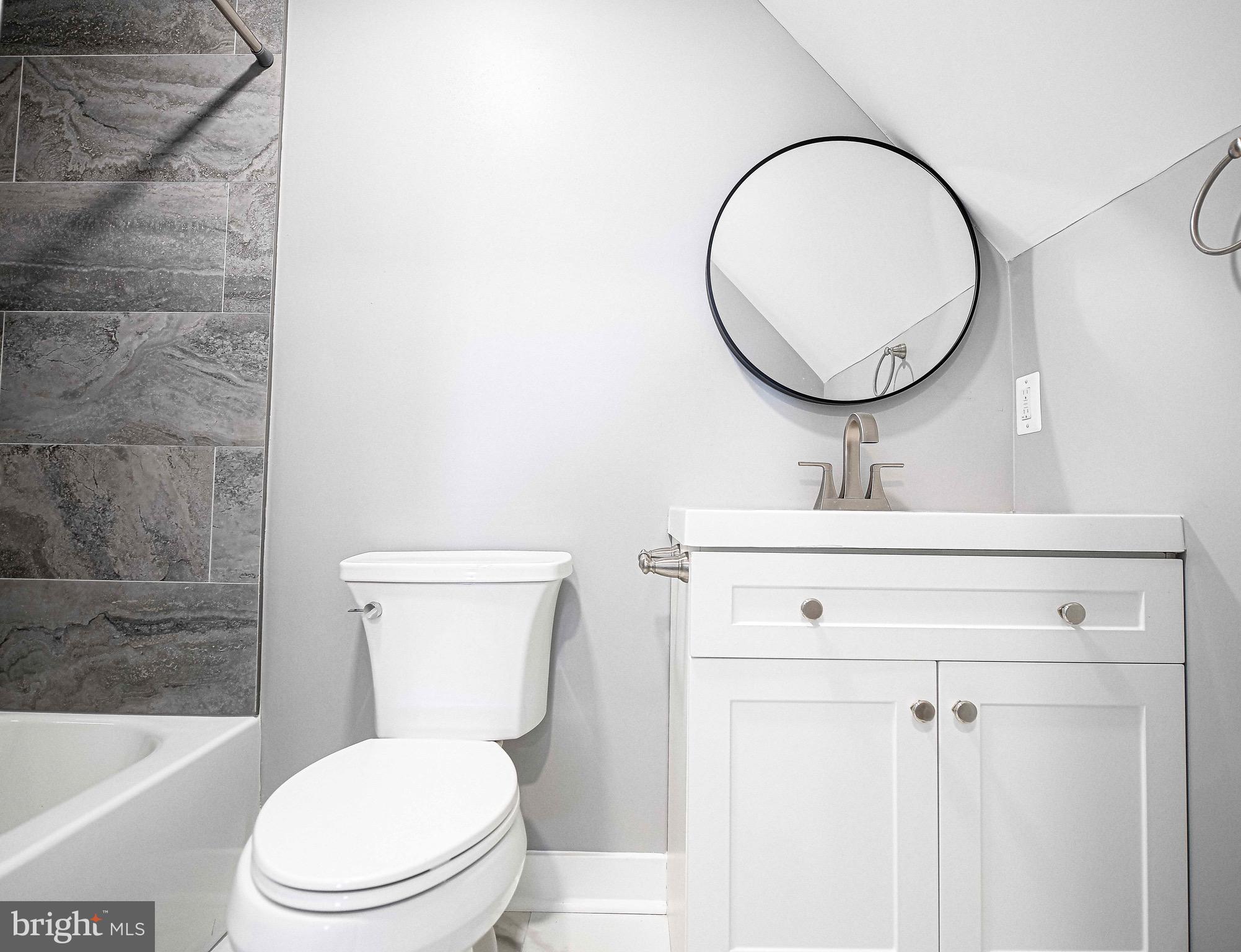 7906 31st Street Rosedale, MD 21237 - Photo 26 of 33 a bathroom with a toilet a sink and a mirror