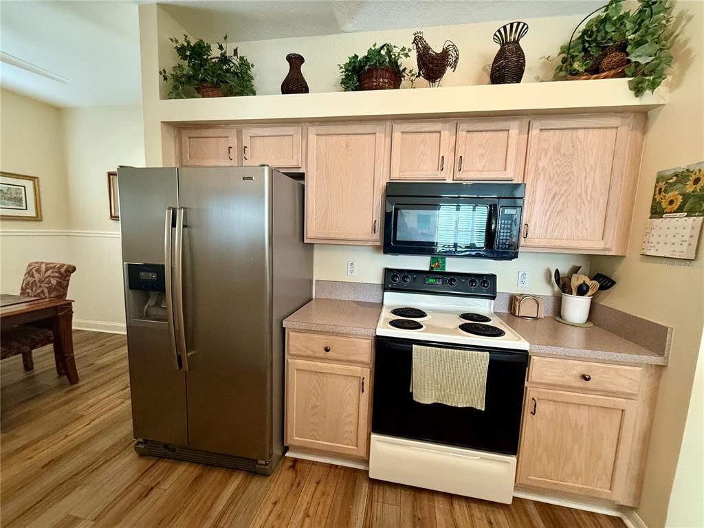 11122 Southwest 73rd Court Ocala, FL 34476 - Photo 11 of 36 a kitchen with stainless steel appliances a stove a microwave a sink and cabinets