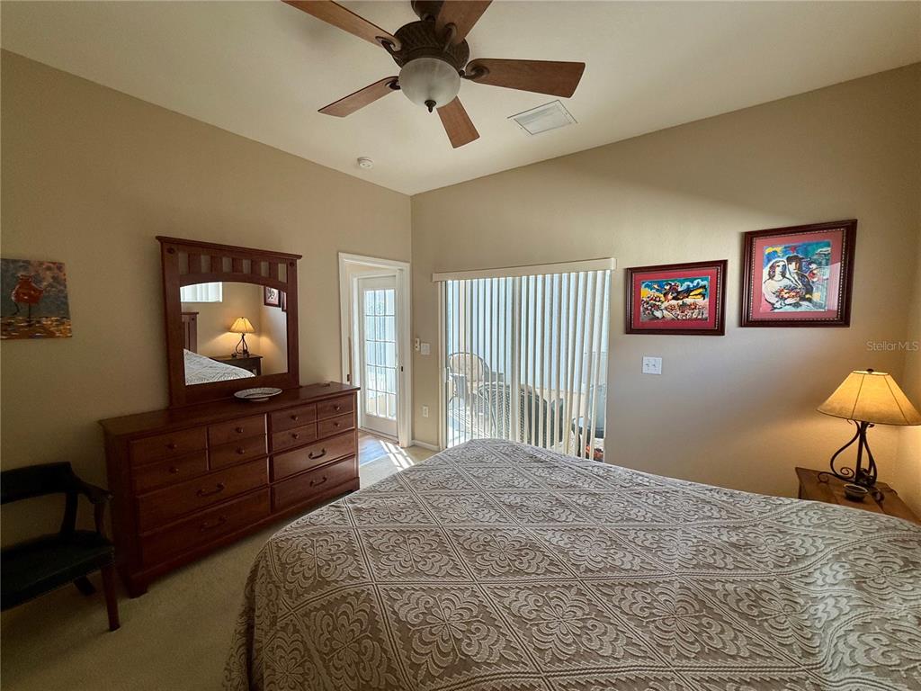 11122 Southwest 73rd Court Ocala, FL 34476 - Photo 21 of 36 a bedroom with a bed and a chandelier