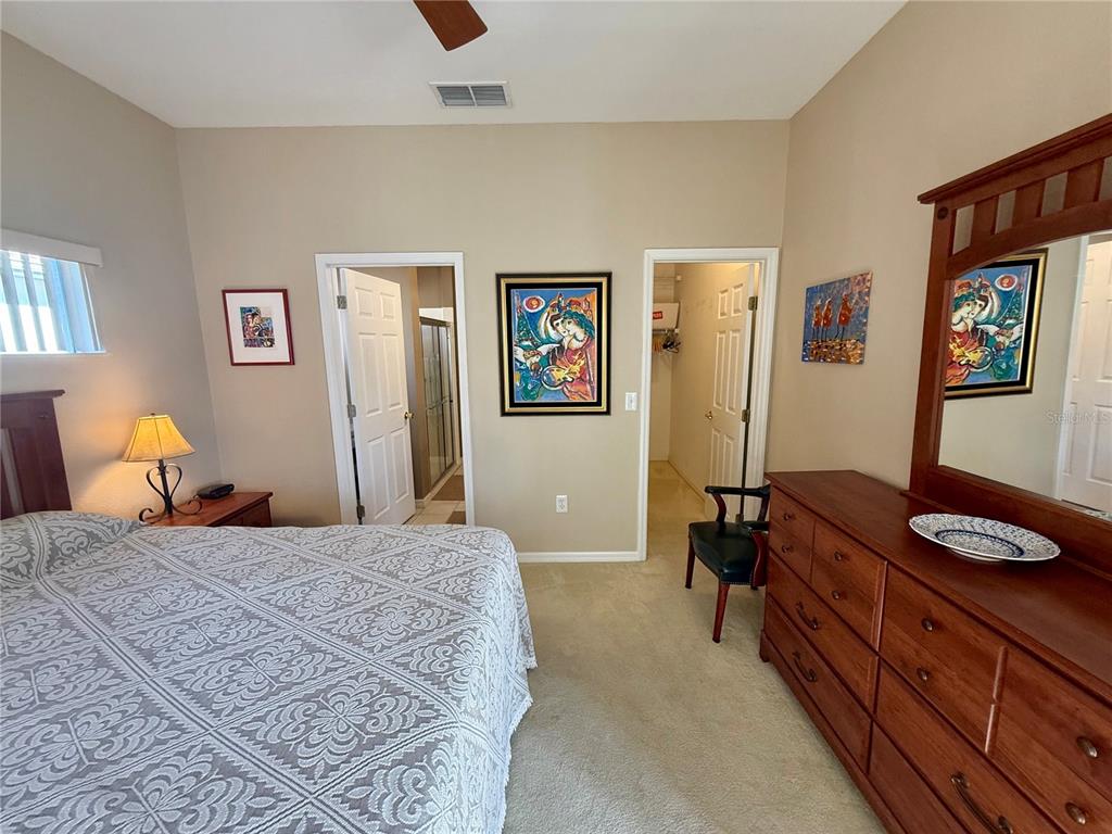 11122 Southwest 73rd Court Ocala, FL 34476 - Photo 22 of 36 a bedroom with a bed and wooden furniture