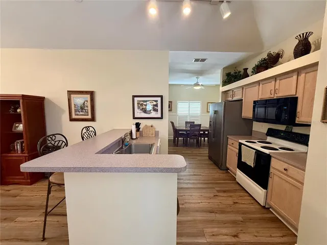 a kitchen with stainless steel appliances kitchen island granite countertop a stove a sink and a microwave