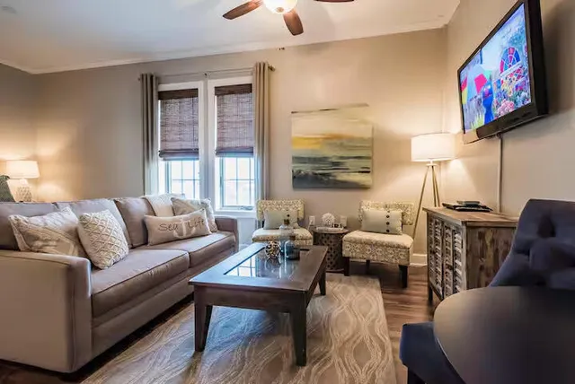 a living room with furniture a flat screen tv and a large window