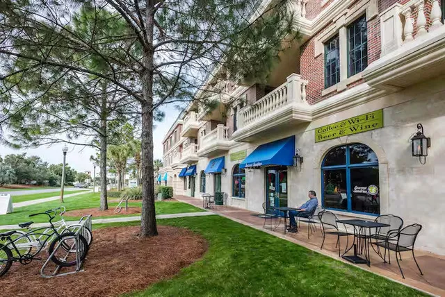 a living room with lots of furniture and a kitchen view