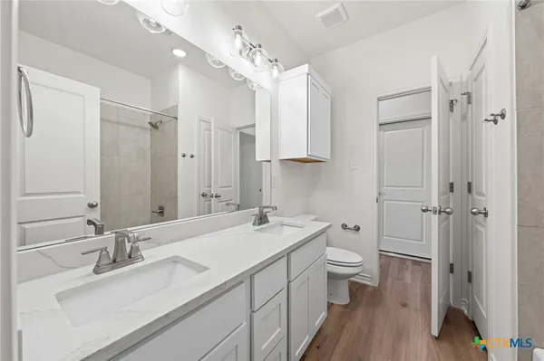 a bathroom with a sink a toilet a shower and a mirror