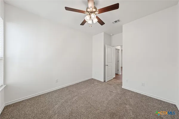 an empty room with chandelier fan