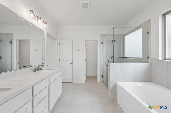 a bathroom with a tub a sink and mirror