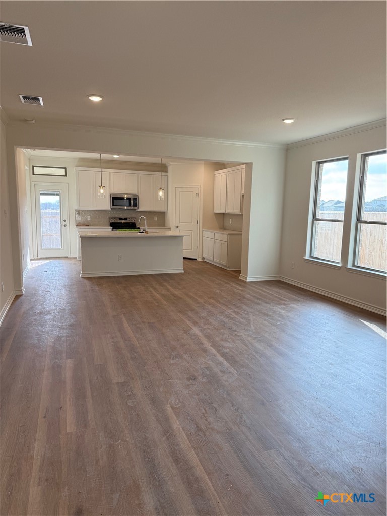 7117 Touchstone Drive Temple, TX 76502 - Photo 5 of 13 a view of kitchen with microwave a stove and wooden floor