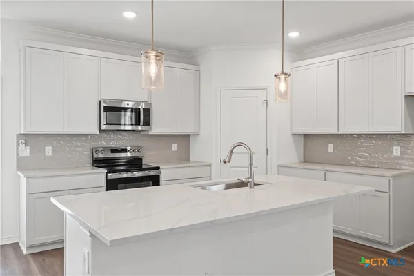 a kitchen with stainless steel appliances a sink a stove a microwave and cabinets