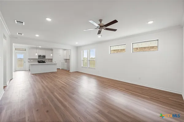 a view of a kitchen with a fridge and wooden floor