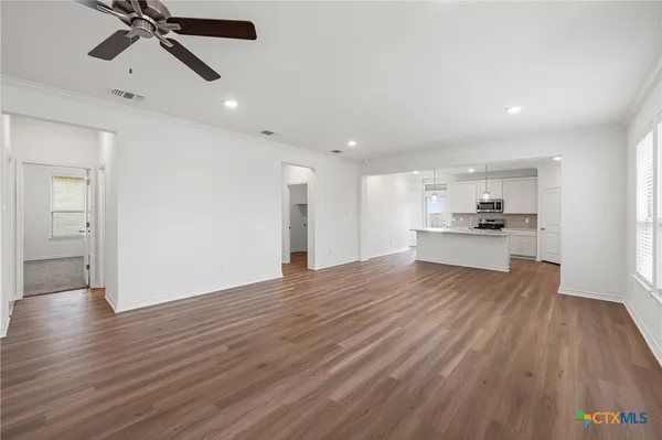 a view of empty room with wooden floor