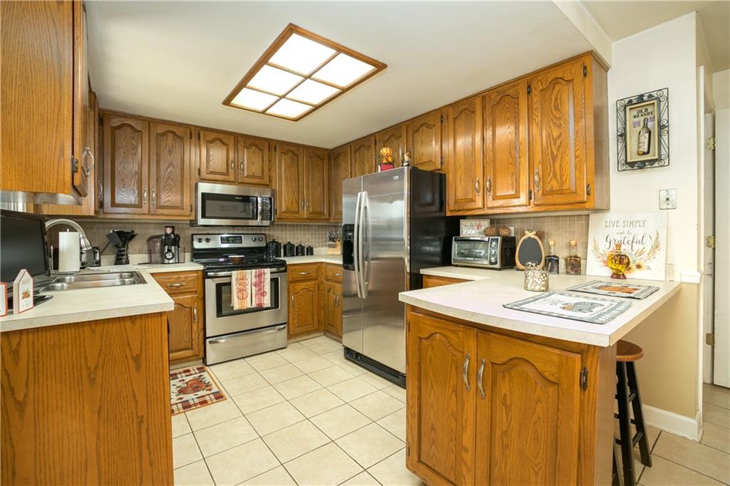 3400 Pittsburgh Road Perryopolis, PA 15473 - Photo 4 of 23 a kitchen with stainless steel appliances granite countertop a sink stove refrigerator and cabinets
