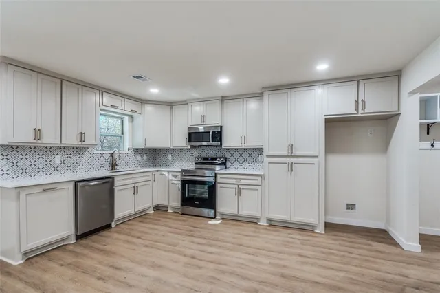 a kitchen with stainless steel appliances granite countertop a stove a sink and a refrigerator