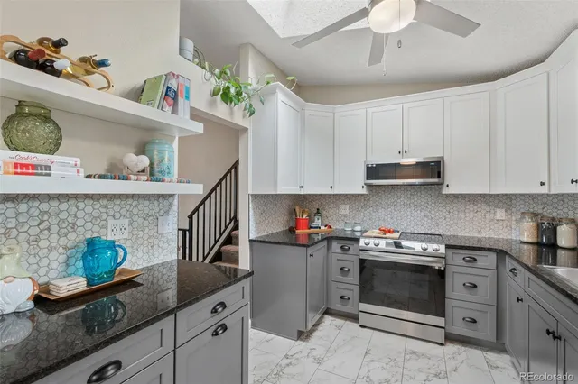 a kitchen with granite countertop lots of clutter and cabinets