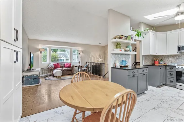 a kitchen with sink refrigerator dining table and chairs