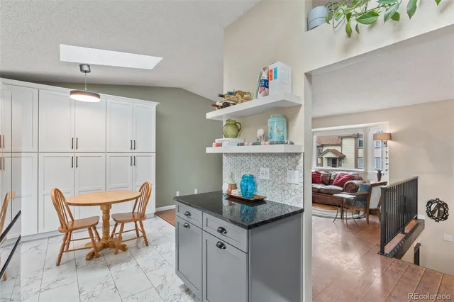 a living room with furniture and a dining table with kitchen view