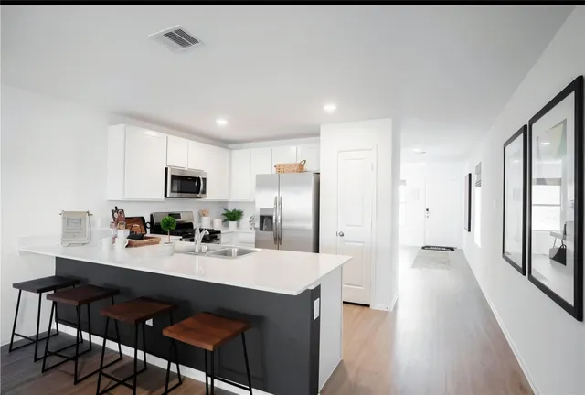 a kitchen with stainless steel appliances a sink stove and refrigerator