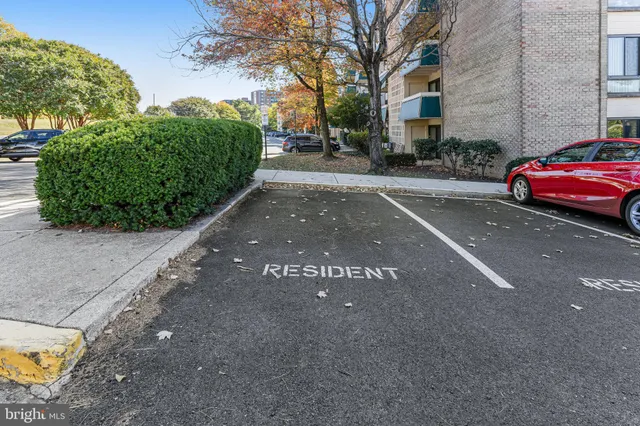 a front view of a building with cars parked