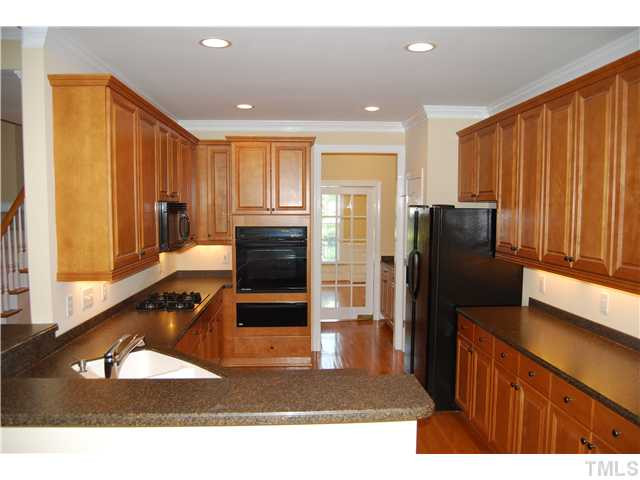 107 Nouveau Avenue Raleigh, NC 27615 - Photo 8 of 25 Gourmet kitchen features gas range, black appliances, warming drawer, solid surface countertops, 42" cabinets, and recessed lighting!