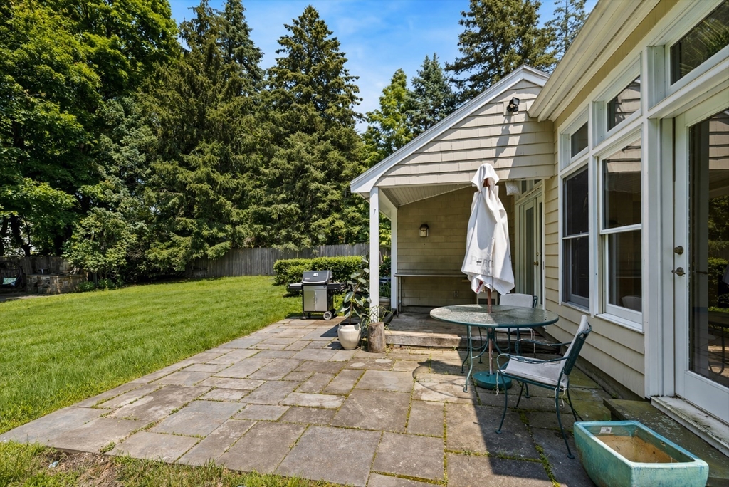 29 Boulevard Road Dedham, MA 02026 - Photo 32 of 34 a view of a patio with table and chairs with wooden fence and plants
