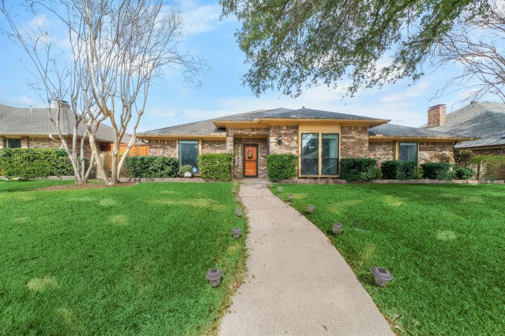 9727 Amberley Drive Dallas, TX 75243 - Photo 1 of 19 a view of a yard with a table and chairs under an umbrella