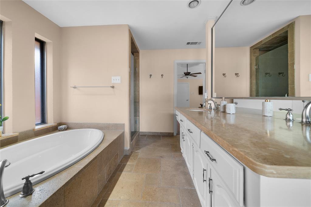 9727 Amberley Drive Dallas, TX 75243 - Photo 12 of 19 a spacious bathroom with a granite countertop double vanity sink a mirror and a bathtub