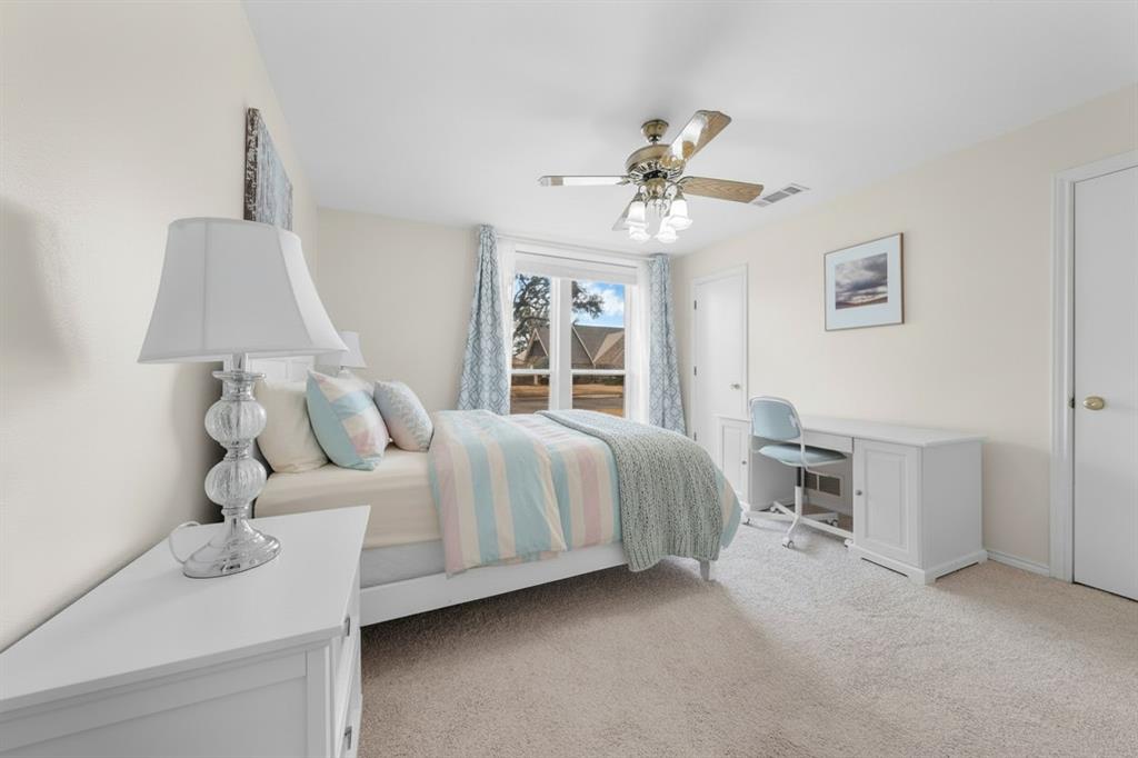 9727 Amberley Drive Dallas, TX 75243 - Photo 14 of 19 a bedroom with a bed and a chandelier
