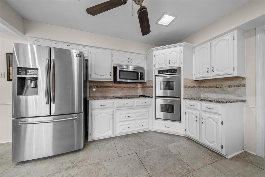 9727 Amberley Drive Dallas, TX 75243 - Photo 5 of 19 a kitchen with stainless steel appliances cabinets a microwave and a refrigerator