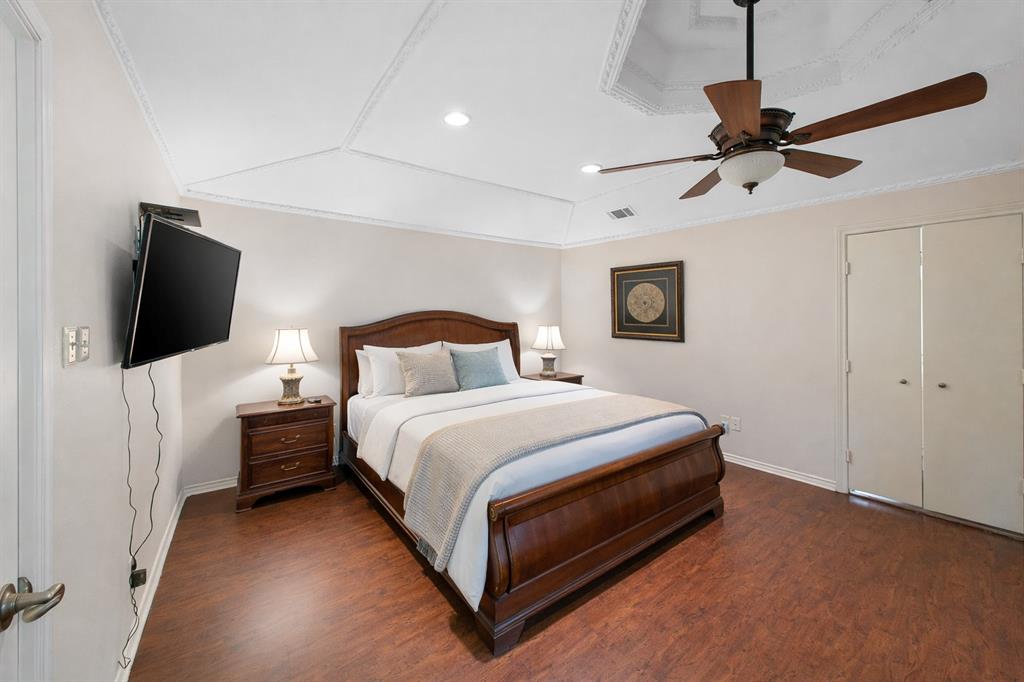 9727 Amberley Drive Dallas, TX 75243 - Photo 9 of 19 a bedroom with a bed tv and a window