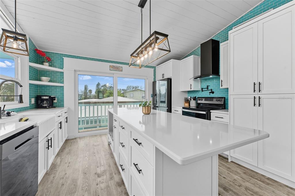 208 Bates Avenue Indian Rocks Beach, FL 33785 - Photo 13 of 47 a kitchen with stainless steel appliances a sink a stove and a refrigerator