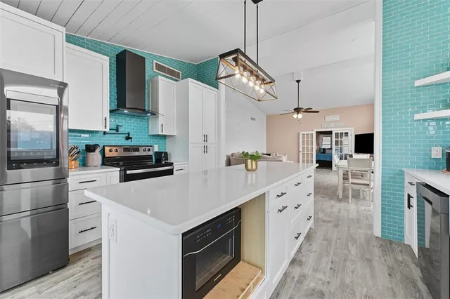 a kitchen with a sink a counter top space stainless steel appliances and cabinets