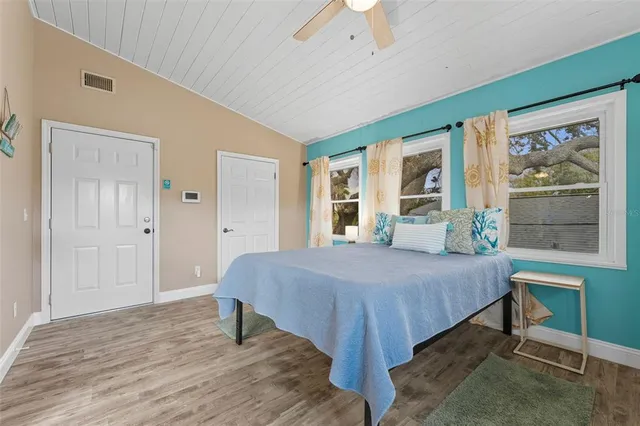 a bed sitting in a spacious bedroom next to a window