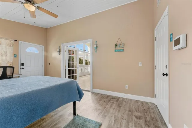 a bedroom with a bed and a large mirror with wooden floor