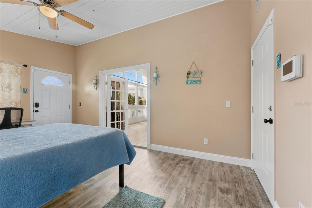 208 Bates Avenue Indian Rocks Beach, FL 33785 - Photo 23 of 47 a bedroom with a bed and a large mirror with wooden floor