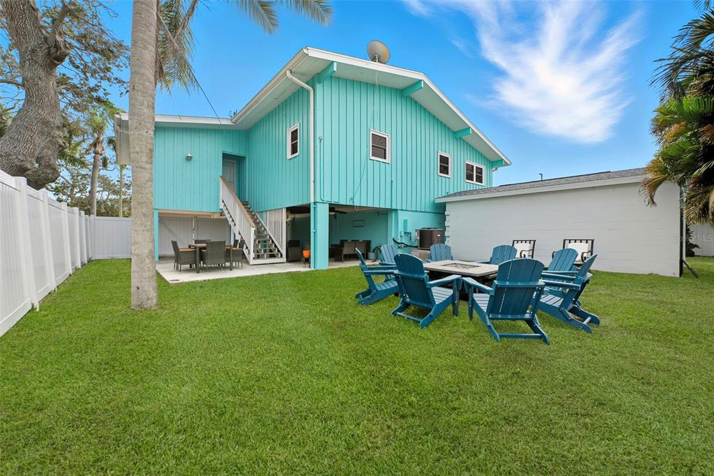 208 Bates Avenue Indian Rocks Beach, FL 33785 - Photo 30 of 47 a backyard of a house with table and chairs